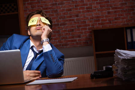 Young businessman working in the office at nightの写真素材