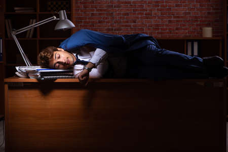 Young businessman working in the office at nightの写真素材