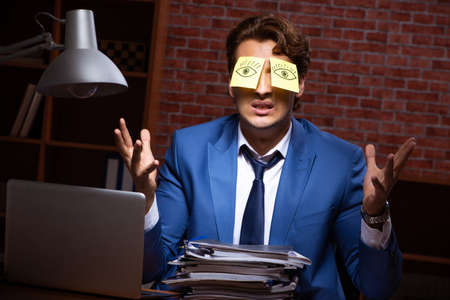 Young businessman working in the office at nightの写真素材