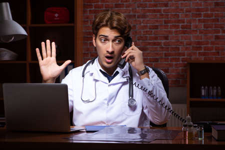 Young handsome doctor working night time at the hospitalの写真素材