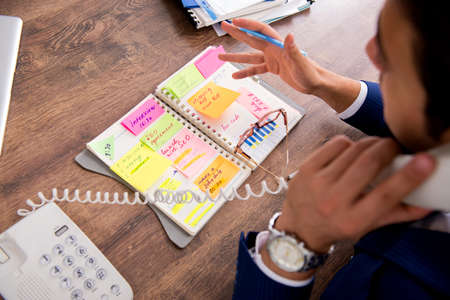 Young handsome employee planning his work activityの写真素材