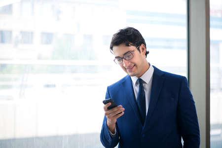 Young handsome businessman standing at the windowの写真素材