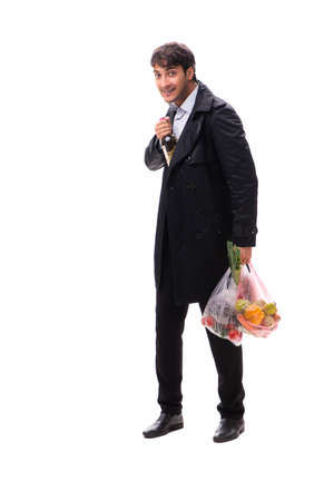 Young handsome man with vegatables in shopping conceptの写真素材