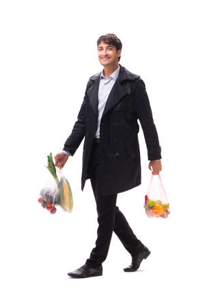 Young handsome man with vegatables in shopping conceptの写真素材