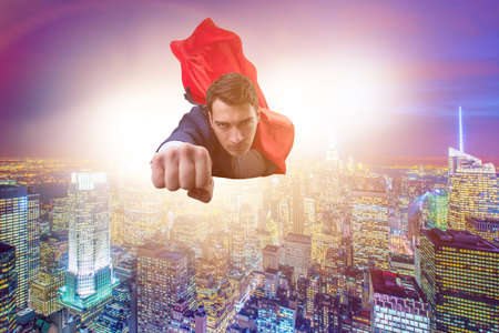 Superhero businessman flying over the cityの写真素材