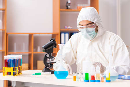 Young biochemist wearing protective suit working in the lab