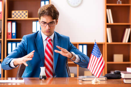 Young handsome politician sitting in officeの写真素材