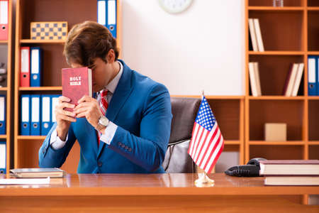 Young handsome politician sitting in officeの写真素材