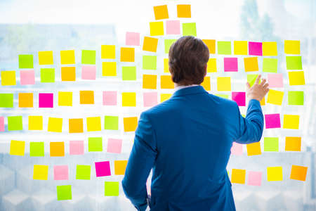 Young handsome employee with many conflicting priorities