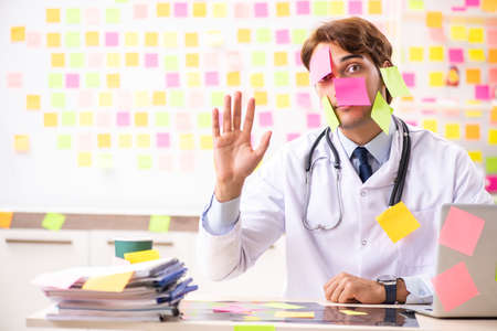 Male doctor with many conflicting priorititesの写真素材