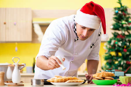 Young chef husband working in kitchen at Christmas eveの写真素材