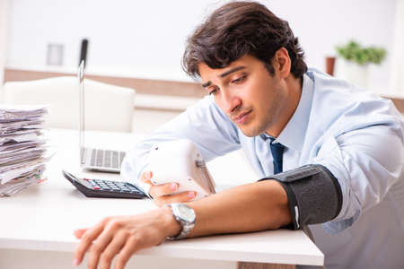 Man under stress measuring his blood pressureの写真素材