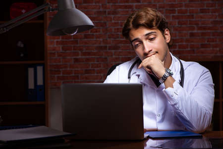 Young handsome doctor working night time at the hospitalの写真素材