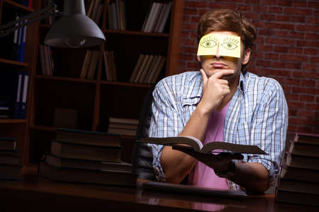 Young handsome student preparing for exams at night