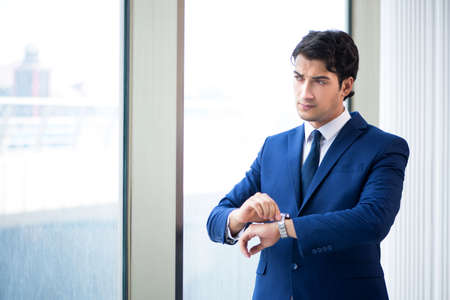 Young handsome businessman standing at the window