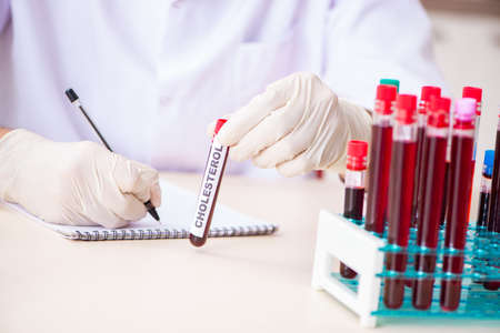 Young handsome lab assistant testing blood samples in hospital