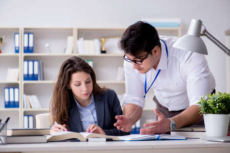 Teacher explaining to student at lectureの写真素材