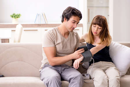 Husband checking wifes blood pressureの写真素材
