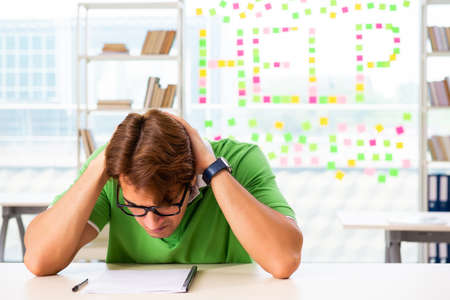 Student struggling at the exam in classroomの写真素材