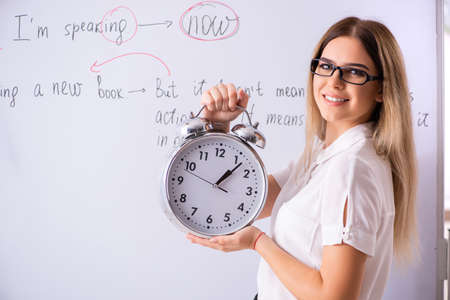 Young female english language teacher standing in front of the b