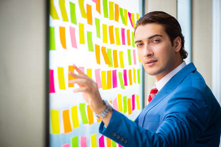 Young handsome employee with many conflicting priorities