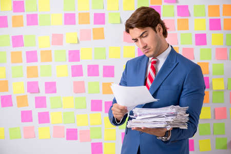 Young handsome man in conflicting priorities conceptの写真素材