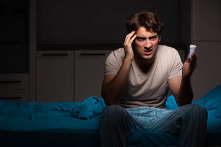 Sick man in his bed with medicinesの写真素材