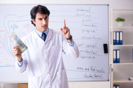 Young handsome dentist in front of the whiteboardの写真素材