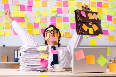 Young employee in conflicting priorities conceptの写真素材