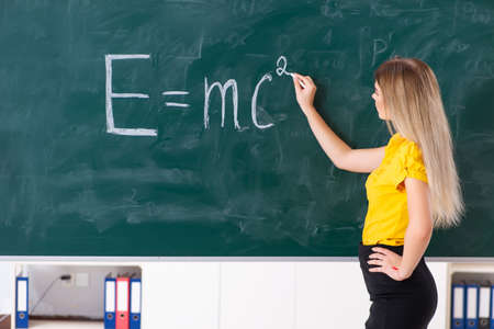 Young female student in front of the chalkboard