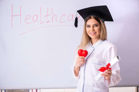 Young female doctor standing in front of the white boardの写真素材