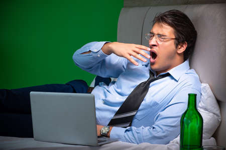 Young businessman under stress in the bedroom at nightの写真素材