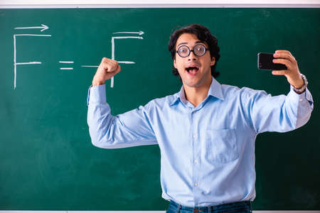 Young male physic standing in front of the green boardの写真素材