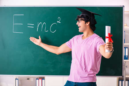Young male physic standing in front of the green board