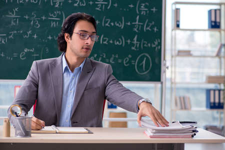 Young handsome math teacher in classroomの写真素材