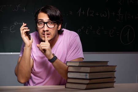 Young male student sitting in classroomの写真素材