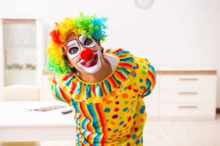 Male clown preparing for perfomance at homeの写真素材