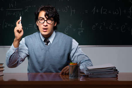 Young math teacher in front of chalkboard