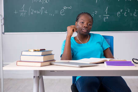 Black female student in front of chalkboard