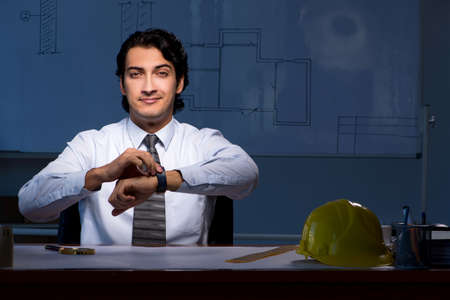 Young construction architect working on project at nightの写真素材