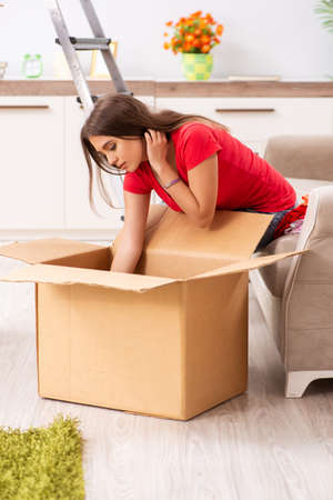 Young beautiful woman moving to new flat