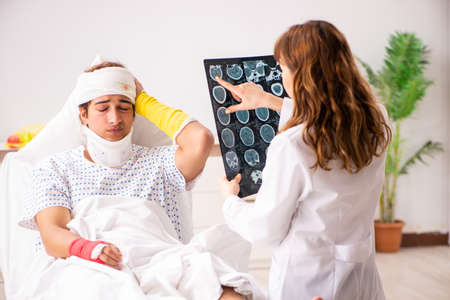 Young doctor examining injured patient
