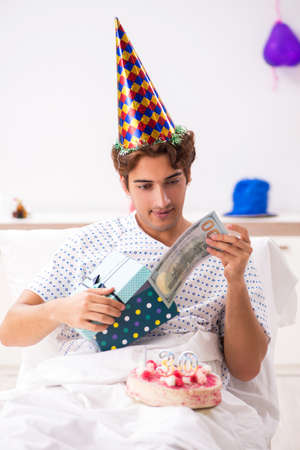 Young man celebrating his birthday in hospitalの写真素材