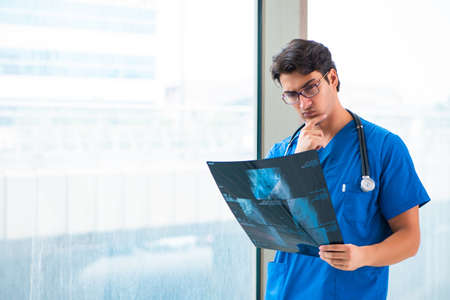 Young handsome doctor working in the hospital