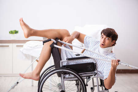 Young handsome man in wheelchair at the hospitalの写真素材