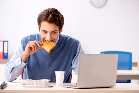 Young handsome employee working in the officeの写真素材