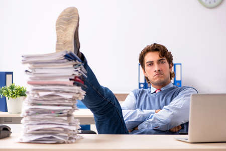 Young handsome employee unhappy with excessive workの写真素材
