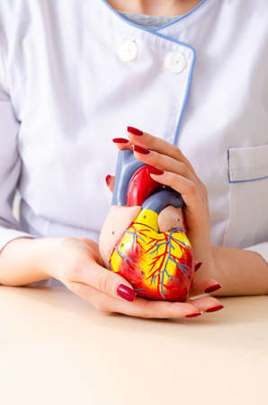 Young female doctor cardiologist sitting at the hospital
