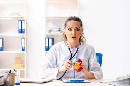 Young female doctor cardiologist sitting at the hospital
