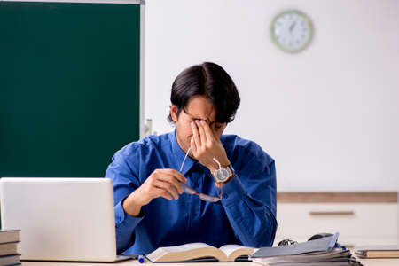 Young male teacher in front of chalkboardの写真素材